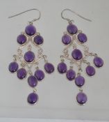 A pair of sterling silver and amethyst cabochon chandelier earrings.Marked 925. 8cm drop.
