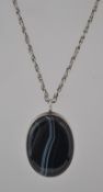 A vintage sterling silver and banded agate oval pendant on a rope twist chain.