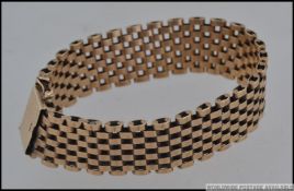 A 9ct gold mesh link bracelet with clip clasp and safety chain. Maker C & F.