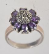 A vintage 925 silver ring set with amethyst and marcasite in a domed flower cluster setting.