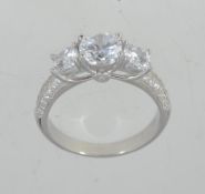 A 925 silver dress ring set with a central prong set CZ stones with pave set CZ shoulders.