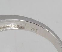 A 925 silver dress ring set with a central amethyst stone surrounded by a CZ halo with channel set