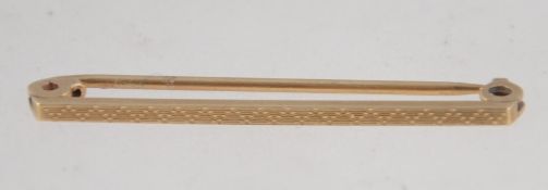 A 9ct gold tie bar pin with chased pyramid decoration. Marked 9ct. Tests 9ct gold. Measures 4cms.