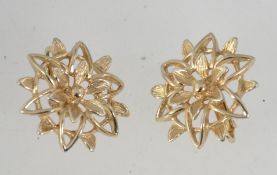 A pair of vintage gold tone Sarah conetry clip on earrings in star flower form with clip fasteners.