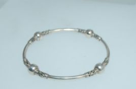 A 925 silver bangle with balanese and ball decoration. Weight 12.5g. Measures 7cms diam.