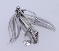A 1950s white metal spray brooch with foliate vine decoration with roller clasp. Measures 6cms.