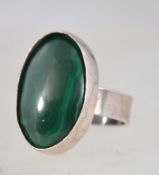 A vintage 925 silver ring set with a large oval malachite in a rub over setting. Marked 925. Size O.