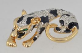 A vintage yellow metal leopard figural brooch with enamel and white metal decoration with roller