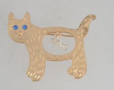 A vintage yellow metal figural brooch in the form of a cat with dangle fish,