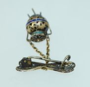 A vintage yellow metal filigree and enamel brooch with drop caldron pendant with c clasp.