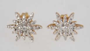 A pair of gold plated 925 silver earrings set with diamond chips in the form of stars.