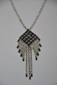 A vintage 1980s black and white rhinestone necklace in a silver tone metal setting with hook