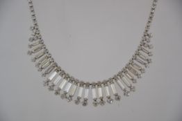A vintage 1950s white rhinestone necklace in a silver tone metal setting with hook fastening.