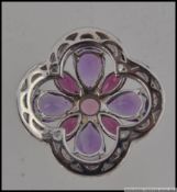 A hallmarked 9ct white gold gem set pendant set with pink and purple gem stones. Size 2cms.