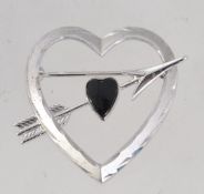 A vintage sterling silver brooch in the form of a heart pierced by an arrow,