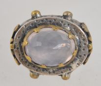 A vintage 925 silver ring set with a large oval faceted rose quartz with yellow metal granulation