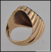 A hallmarked 9ct gold blood stone signet ring with central blood stone in a scalloped setting.