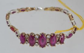 A silver metal CZ and rubilite stone set bracelet / bangle of contemporary form.