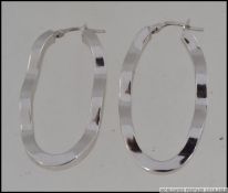 A pair of hallmarked 9ct white gold hoop earrings in a wave form set with CZ. Weight 5.