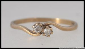 A hallmarked 9ct gold diamond ring with two cathedral set diamonds in a wrap over setting. Size M.