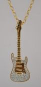 A 925 silver pendant necklace with gold vermeil stung with a rhinestone encrusted guitar.