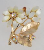 A large 1960s god tone flower spray brooch with aurora rhinestones and moon glow plastic cabochons