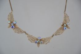 A vintage 1950's yellow metal necklace with stylised leaves with Aurora Borealis stones.