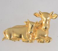 A vintage signed yellow metal figural brooch in the form of a cow and calf with roller clasp.