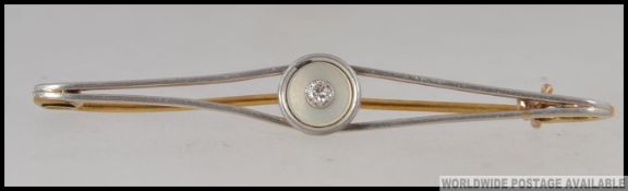 An 18ct gold tested diamond Art Deco bar brooch set with a central old cut diamond in a rope twist