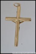 A large 375 9ct hallmarked gold crucifix pendant Marked with CCM and London 375. Weight 2.1g.