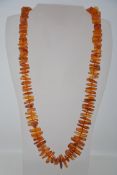 A vintage amber graduated pebble bead necklace. Largest bead 2.5cms. length 68cms.
