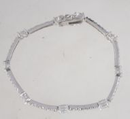 A 925 silver tennis bracelet set with round and oval cut clear stones with twin safety catch and