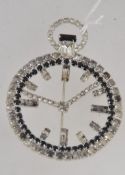 A vintage silver tone figural brooch in the form of a pocket watch with channel set rhinestone
