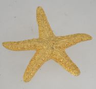 A vintage signed gold tone figural brooch in the form of a starfish with texture body and roller