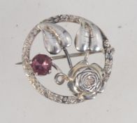 A vintage 1930's 40's sterling silver brooch in the form of leaves and a rose within a roundel set