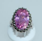 A 925 silver ring set with an oval cut pink gem stone surrounded by a marcasite halo. Size O.