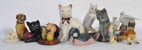 A collection of animal porcelain figurines to include cats , owls , dogs , swans etc.