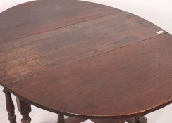 A 1920's oak drop leaf dining table raised on barley twist legs with drop leaves of oval shape.