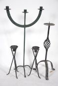 A wrought iron three branch candelabra along with a pair of 20th Century cast iron candlesticks of
