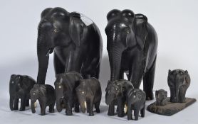 A group of carved ebony elephants of various sources with bone inlaid features
