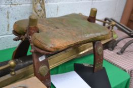 A 20th century Camel stool having a hard wood frame with brass work decoration