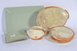 A collection of fish plates of varying sizes along with a matching pouring jug accompanied by a set