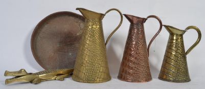 A 19th Century copper jug of snakeskin design stamped JS & S along with two similar brass jugs