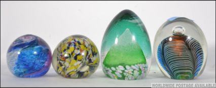 a collection of four glass paperweights