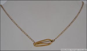 A 9ct gold brooch chain with shaped clip