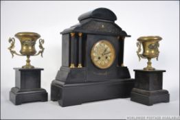 A Victorian slate mantel clock garniture