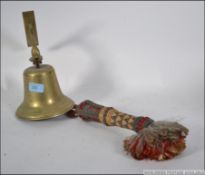 A vintage wall hanging brass bell with a