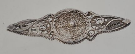 A Victorian silver filigree worked brooch with central roundel design, pin verso.