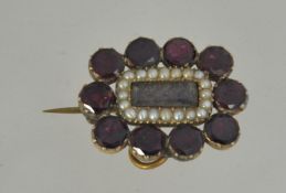 A Georgian 9ct gold, almandine garnet and seed pearl mourning locket with inset platted hair.