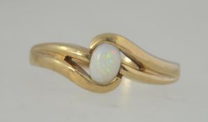 A hallmarked 9ct gold ring set with a central opal in a cross over setting.